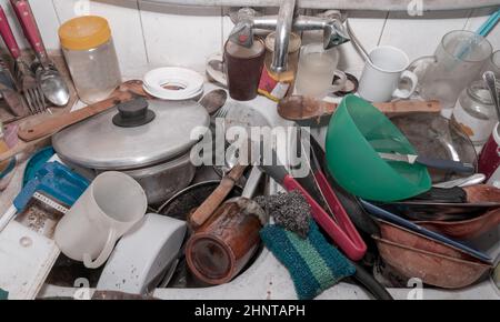 Mucchio di piatti sporchi nel lavandino in vecchia casa Foto Stock