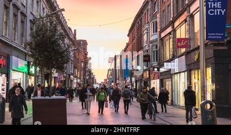 Gente che cammina lungo una strada commerciale di Dublino, Irlanda Foto Stock