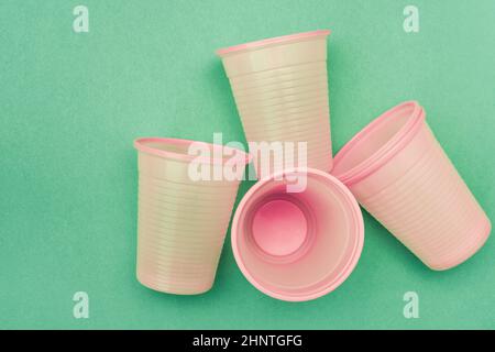 Svuotare le tazze di plastica rosa monouso sullo sfondo blu Foto Stock