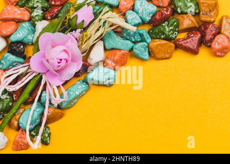 Decorazioni natalizie. Ciottoli caramelle. Dolci in pietra colorata su sfondo giallo. Spazio per copia Foto Stock