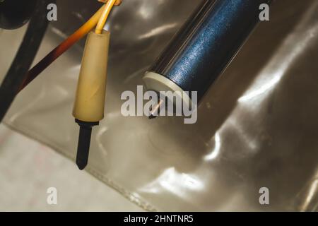 Sonde elettriche vecchie appese in officina. Sonda multimetro Foto Stock