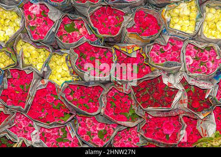 Rose rosse e gialle imballate in giornale al mercato dei fiori Pak Khlong Talat a Chinatown di Bangkok, Thailandia Foto Stock