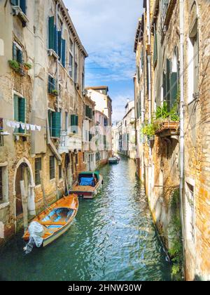Canale veneziano con barche e vista sulla laguna. Foto Stock