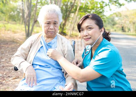 Medico che usa stetoscopio per controllare il paziente nel parco, sano concetto medico forte Foto Stock