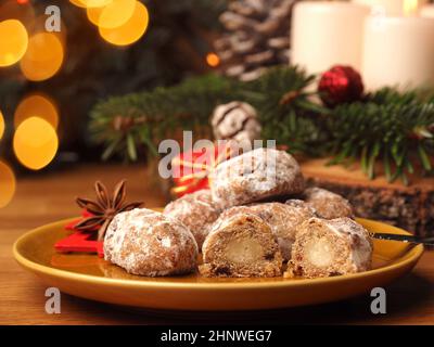 Delizioso stollen di Natale su un piatto di ceramica di fronte a una corona di Avvento e decorazioni natalizie, cibo di stagione Foto Stock