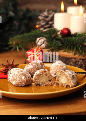 Delizioso stollen di Natale su un piatto di ceramica di fronte a una corona di Avvento e decorazioni natalizie, cibo di stagione Foto Stock