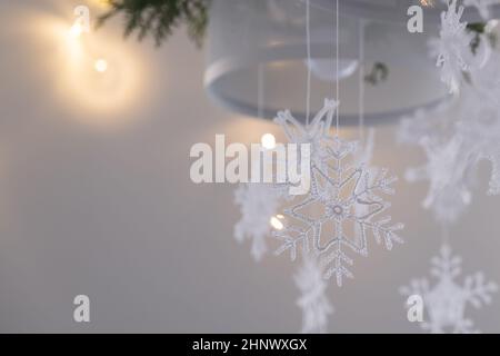 Decorazioni natalizie fatte a mano. Interni di Natale o Capodanno con varietà di delicati fiocchi di neve in maglia bianca. Messa a fuoco selettiva. Foto Stock