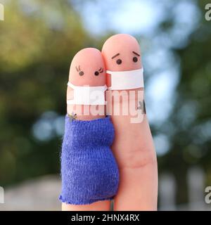 Fingers arte di coppia in maschera medica da COVID-2019. La donna è incinta. Foto Stock