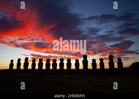 Drammatico e colorato sorgere del sole sulle sculture di pietra di Moai a AHU Tongariki, isola di Pasqua, Cile Foto Stock
