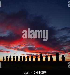 Drammatico e colorato sorgere del sole sulle sculture di pietra di Moai a AHU Tongariki, isola di Pasqua, Cile Foto Stock