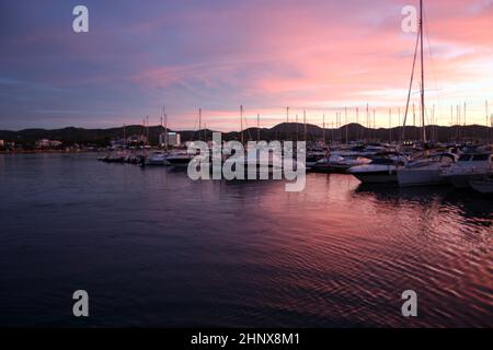 romantico tramonto rosa sulle acque marine del porto di san antonio a ibiza nelle isole baleari Foto Stock