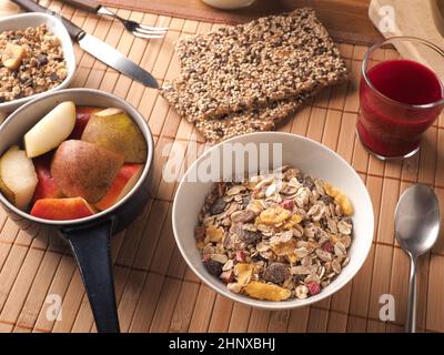 Ricca prima colazione con cereali biologici e ingredienti su un tavolo di legno, concetto di cibo sano Foto Stock