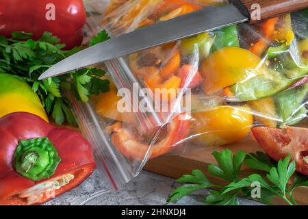 Affettato frutti maturi di peperone in sacchetti di cellophane, preparati per il congelamento e la conservazione a lungo termine nel comparto freezer del frigorifero. V. Anteriore Foto Stock