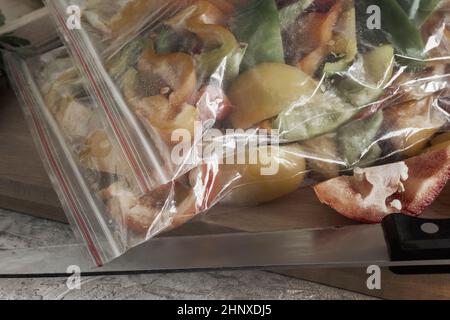 Affettato frutti maturi di peperone in sacchetti di cellophane, preparati per il congelamento e la conservazione a lungo termine nel comparto freezer del frigorifero. V. Anteriore Foto Stock