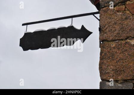Un puntatore in vecchio stile è appeso alla parete dell'edificio contro il cielo, con spazio libero per il testo Foto Stock