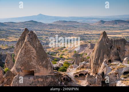 Bellissimo paesaggio al tramonto nella valle della Cappadocia con antiche case grotta in primo piano Foto Stock