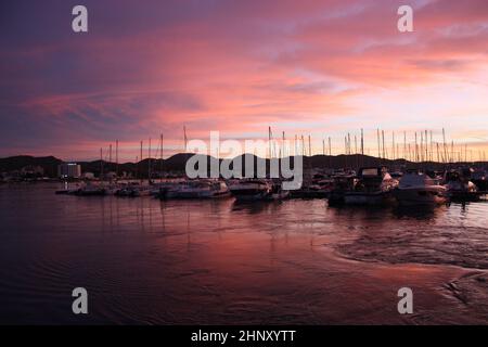 romantico tramonto rosa sulle acque marine del porto di san antonio a ibiza nelle isole baleari Foto Stock