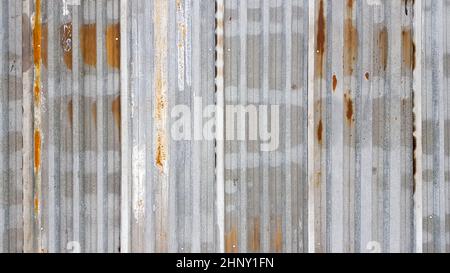 Un pezzo di metallo corrugato arrugginito e resistente agli agenti atmosferici. Lamiera di ferro zincata corrosa. Fondo parete di zinco vecchio Foto Stock