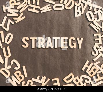 Parola di strategia in legno Cubo Alphabet Letters Top View on A Rustic paper background. Foto Stock