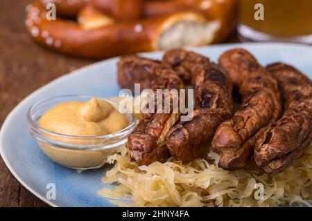 Salsicce di Norimberga con crauti su un piatto Foto Stock