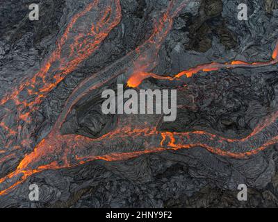 Droneshot di lava che scorre in diversi corsi d'acqua al vulcano Fagradersfjall, Islanda Foto Stock