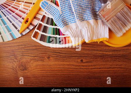 vari strumenti di pittura e campioni di colore su sfondo di legno. Foto Stock