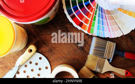 Vari strumenti di pittura, gli accessori e i campioni di colore per il restauro di casa su sfondo di legno . Foto Stock