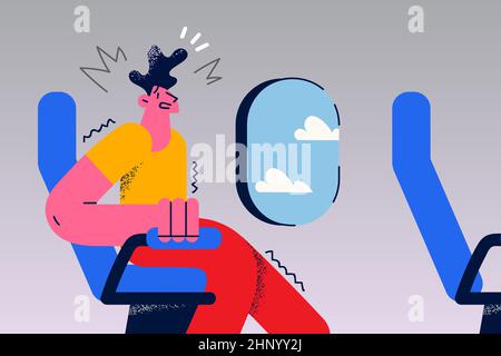 Il giovane uomo stressato si siede in sedia di aereo hanno attacco di panico sentire paura di volare. Ragazzo infelice preoccupato per il volo aereo. Concetto di Aerofobia. Ment Foto Stock