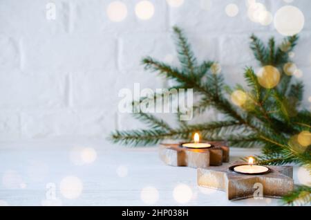 Decorazioni minimaliste natalizie in interni scandinavi candele in legno a forma di albero di Natale e stella. Spazio di copia Foto Stock
