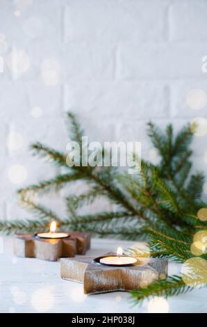 Decorazioni minimaliste natalizie in interni scandinavi candele in legno a forma di albero di Natale e stella. Spazio di copia Foto Stock