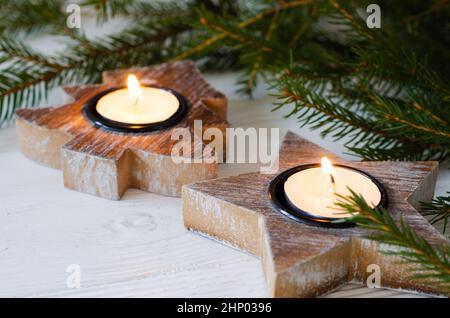 Decorazioni minimaliste di Natale in interni scandinavi. Candelieri di legno a forma di albero di Natale e stella Foto Stock