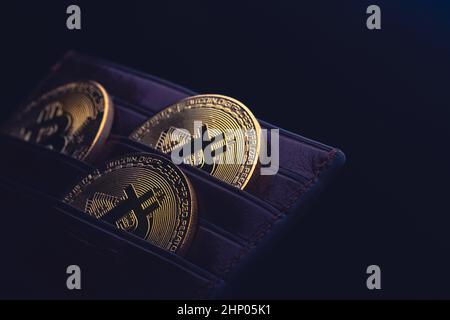 vista laterale primo piano concetto di bitcoin criptocurrency monete d'oro in cuoio nero denaro portafoglio Foto Stock