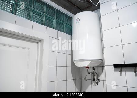 Riscaldatore dell'acqua di bilancio della famiglia appeso alla parete nella stanza della caldaia. Moderna caldaia a gas in bagno. ?ommon riscaldatore di acqua del serbatoio di deposito elettrico. Hom Foto Stock