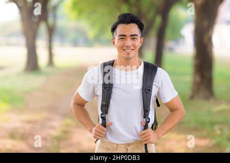 Sorridente giovane asiatico che guarda la macchina fotografica Foto Stock
