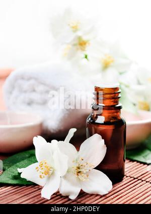 Olio essenziale di fiori di gelsomino su sfondo di legno Foto Stock