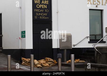 I sacchi di sabbia proteggono una proprietà a Lahinch, Co Clare, mentre Storm Eunice continua a infuriare in tutta l'Irlanda. Più di 55.000 case, fattorie e aziende erano senza potere sull'isola il venerdì mattina, mentre la tempesta seguiva verso est in tutta la Repubblica. Le contee di Cork, Kerry e il sud del paese hanno portato il peso della tempesta maggiore finora, che ha portato venti e neve alti a parti dell'isola. Data immagine: Venerdì 18 febbraio 2022. Foto Stock