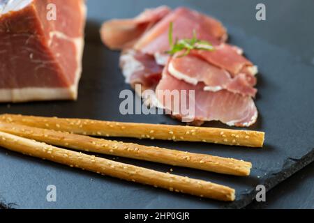 Prosciutto italiano servito con grissini Foto Stock