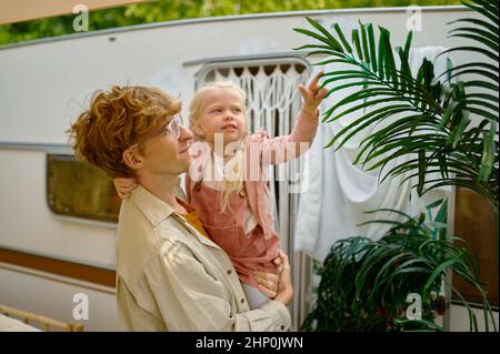 Padre e garghter divertirsi al rimorchio, campeggio estivo. La famiglia con bambini viaggia in auto da campeggio, natura e foresta sullo sfondo. Campeggio avventurur Foto Stock