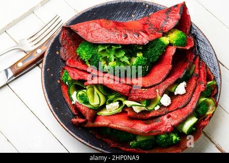 Frittelle di barbabietole colorate con broccoli e cetrioli. Foto Stock