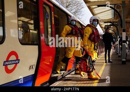 Brad Johnson (a destra) e Nick Walton sbarcano la metropolitana di Londra a Turnham Green in un kit salvavita completo mentre tentano di visitare 200 stazioni della metropolitana in un giorno per raccogliere fondi per la RNLI. Data immagine: Venerdì 18 febbraio 2022. Oltre a visitare un doppio secolo di stazioni, il Pair visiterà anche tutte e quattro le stazioni RNLI Thames Lifeboat (Chiswick, Teddington, Tower e Gravesend) durante il fine settimana. Foto Stock