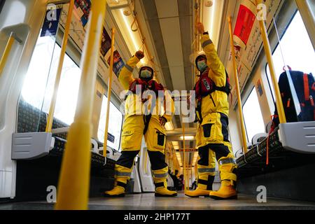 I volontari di Lifestboat Brad Johnson (a destra) e Nick Walton a bordo della metropolitana di Londra in kit salvavita completo mentre tentano di visitare 200 stazioni della metropolitana in un giorno per raccogliere fondi per la RNLI. Data immagine: Venerdì 18 febbraio 2022. Oltre a visitare un doppio secolo di stazioni, il Pair visiterà anche tutte e quattro le stazioni RNLI Thames Lifeboat (Chiswick, Teddington, Tower e Gravesend) durante il fine settimana. Foto Stock