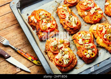 Sottile strato di carne, impanato in pangrattato con formaggio, olive e pomodoro. Piatto di carne - schnitzel Foto Stock
