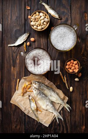 Bevanda alcolica pinta di lager e pinta di stout, birra artigianale. Due bicchieri di birra con schiuma e spuntini su sfondo rustico in legno. tradizionale tedesco wh Foto Stock