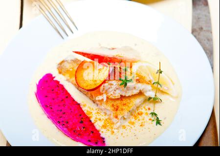 Orate di mare orata filetto burro pan fritto con pesche fresche di potare e fette dragonfruit timo sulla parte superiore Foto Stock