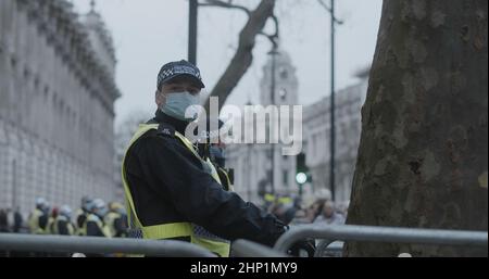 Londra, UK - 01 22 2022: Un poliziotto maschile che indossa una maschera facciale, in linea sulla strada Whitehall guardia Downing Street. Foto Stock