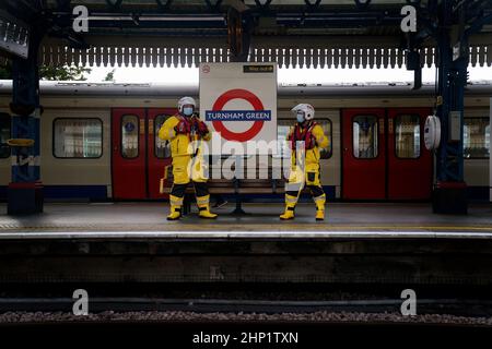 I volontari di Lifestboat Brad Johnson e Nick Walton alla stazione della metropolitana di Turnham Green prendono alla metropolitana di Londra in un kit salvavita completo e tentano di visitare 200 stazioni della metropolitana in un giorno per raccogliere fondi per la RNLI. Data immagine: Venerdì 18 febbraio 2022. Oltre a visitare un doppio secolo di stazioni, il Pair visiterà anche tutte e quattro le stazioni RNLI Thames Lifeboat (Chiswick, Teddington, Tower e Gravesend) durante il fine settimana. Foto Stock