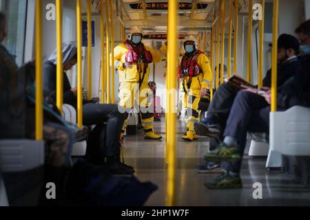 I volontari di Lifestboat Brad Johnson e Nick Walton sulla District Line mentre prendono alla metropolitana di Londra in un kit salvavita completo e cercano di visitare 200 stazioni della metropolitana in un giorno per raccogliere fondi per la RNLI. Data immagine: Venerdì 18 febbraio 2022. Oltre a visitare un doppio secolo di stazioni, il Pair visiterà anche tutte e quattro le stazioni RNLI Thames Lifeboat (Chiswick, Teddington, Tower e Gravesend) durante il fine settimana. Foto Stock