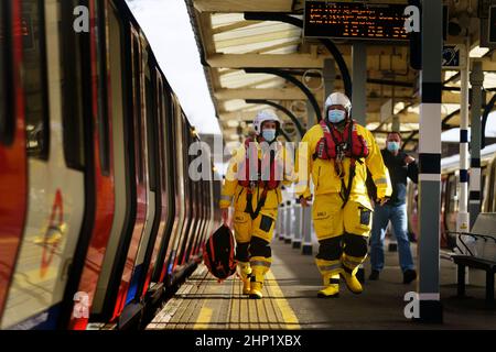 I volontari di salvagente Brad Johnson e Nick Walton alla stazione della metropolitana di Richmond, mentre prendono la metropolitana di Londra in un kit salvavita completo e tentano di visitare 200 stazioni della metropolitana in un giorno per raccogliere fondi per la RNLI. Data immagine: Venerdì 18 febbraio 2022. Oltre a visitare un doppio secolo di stazioni, il Pair visiterà anche tutte e quattro le stazioni RNLI Thames Lifeboat (Chiswick, Teddington, Tower e Gravesend) durante il fine settimana. Foto Stock