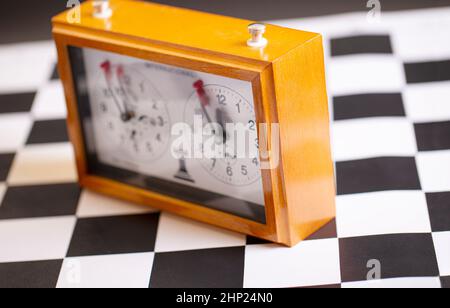 Il classico orologio a scacchi meccanico su scacchiera di legno. Messa a fuoco selettiva Foto Stock