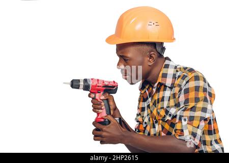 African American lavoratore edile nel casco utilizza cacciavite elettrico Foto Stock